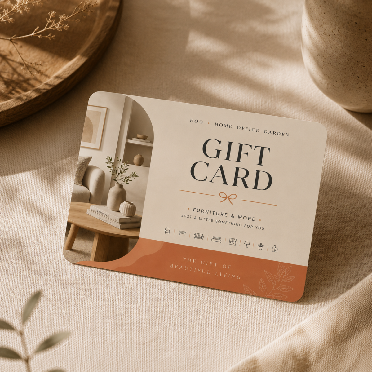 Elegant HOG Furniture gift card displayed in a warm lifestyle vignette with soft neutral décor styling