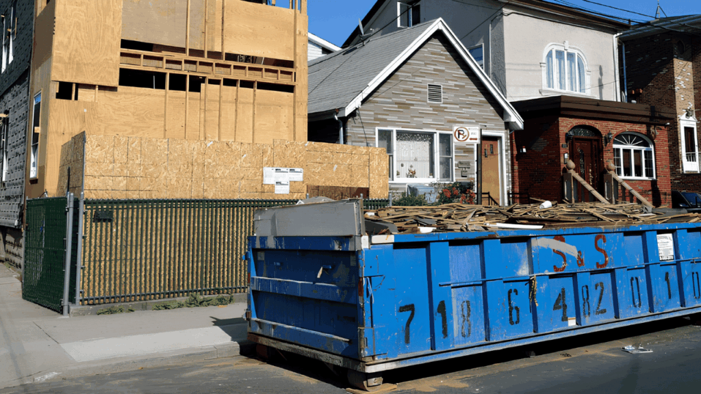 Large dumpster container placed at a construction site for waste disposal during home renovation cleanup
