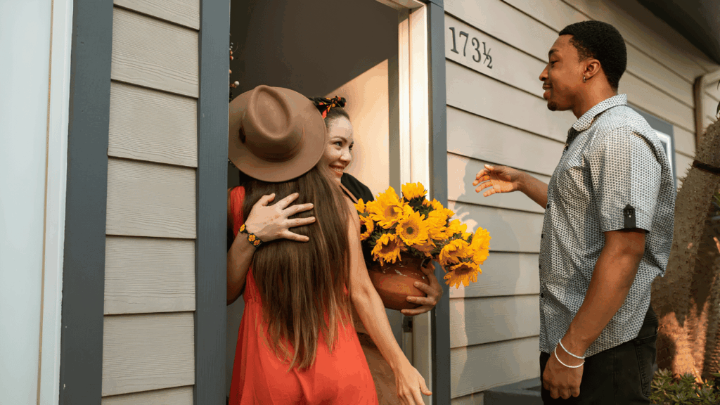 Beautifully arranged housewarming gifts including home décor items, kitchen essentials, candles, and plants in a cozy living room setting
