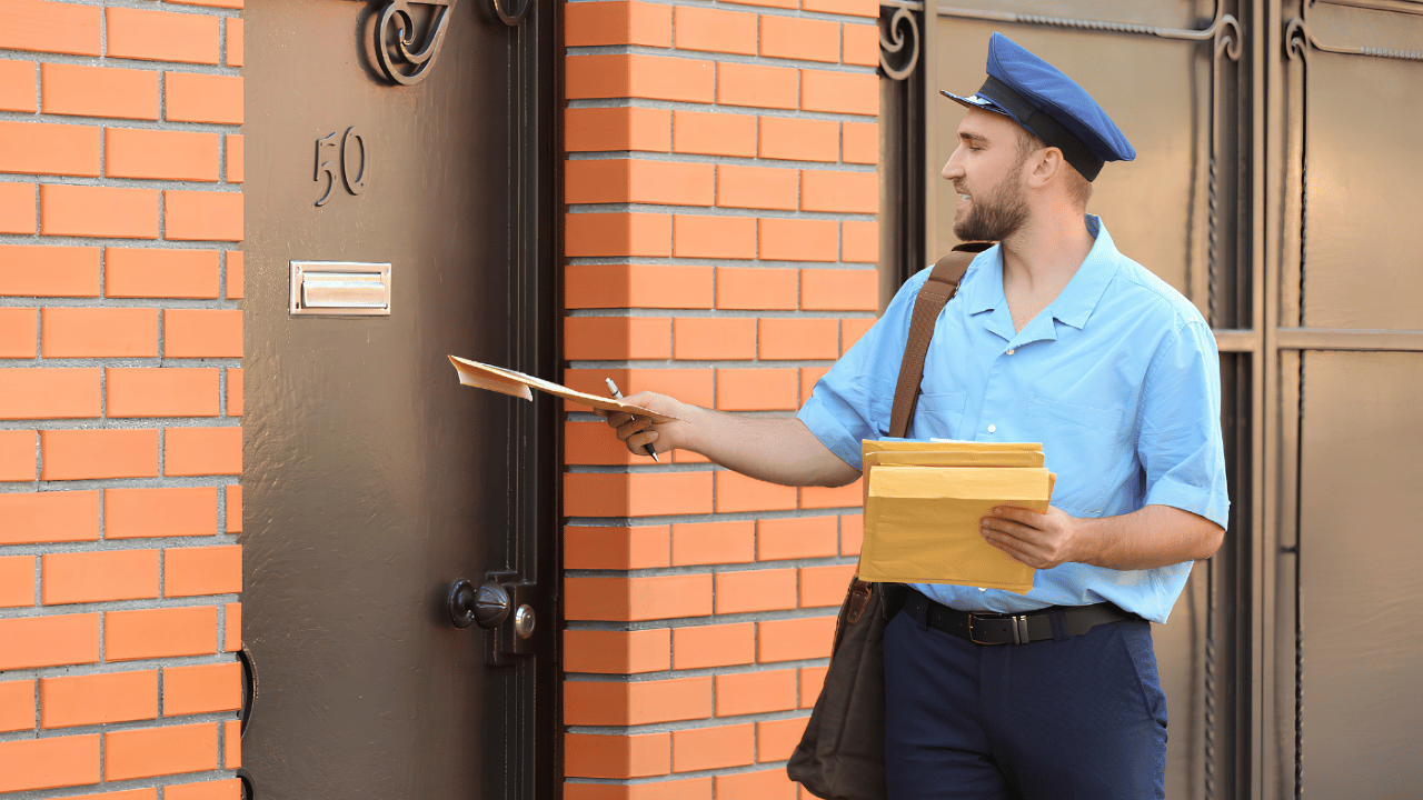 Mail carrier delivering package to the correct home address in a residential area